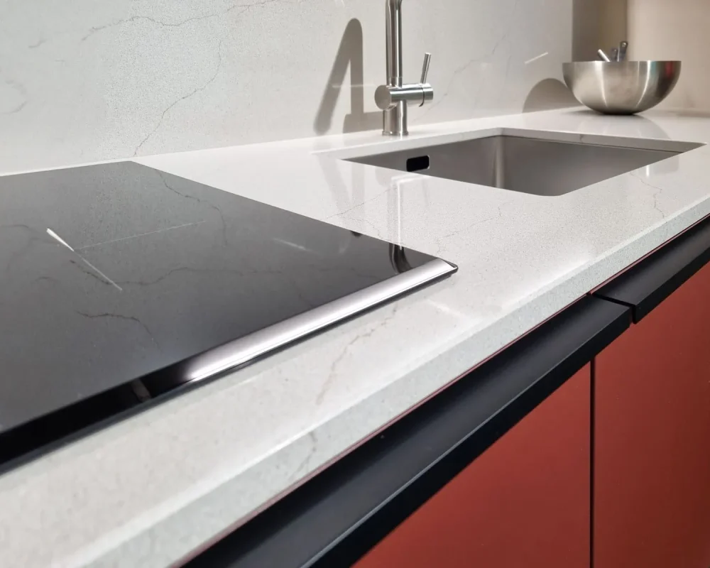 stone-italiana-cosmolite-materiale-ecosostenibile-venantis-grey-argo-vena-passante-top-cucina-paraschizzi-dettaglio-induzione-e-lavandino.jpg